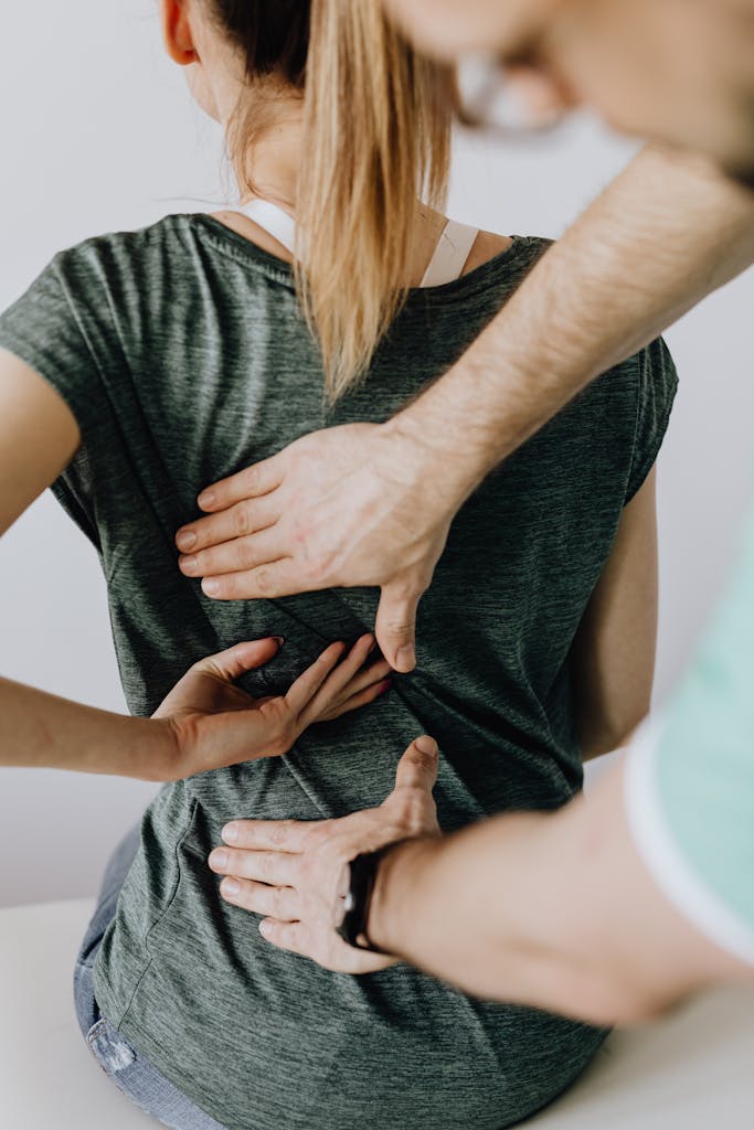 Orthopedist examining the back of a woman patient.